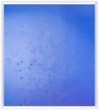 Color image of a color photograph depicting details of water in a blue hue framed in white
