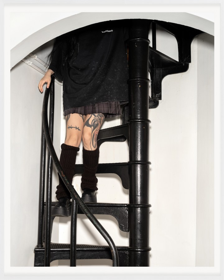 A color photograph of a figure descending a spiral staircase