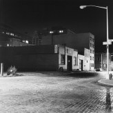 Black and white photograph of an empty street at night