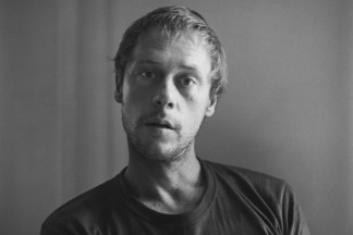 Black and white photograph of a slightly blurred male figure looking at the viewer
