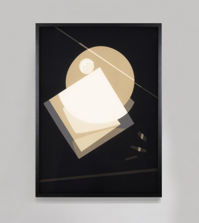 Color image of a color transparency on a light box depicting a darkly framed abstract image of overlapping geometric shapes hung on a grey wall
