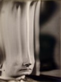 Black and white photograph of a distorted face stretched in the middle