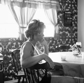 Black and white photograph of a women's profile seated at table