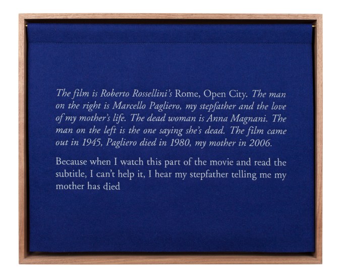 A wooden box with a blue curtian, embroidered with white text, describing the artist's stepfather