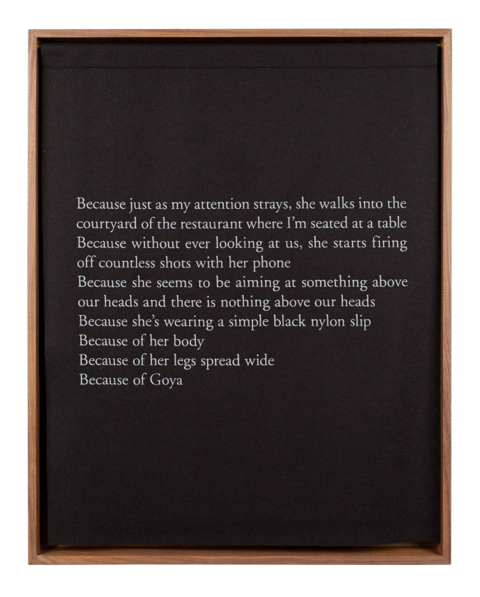 A wooden box with a black curtain, embroidered with white text, describing a photograph of a woman