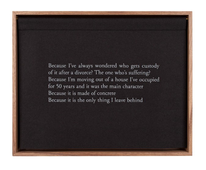 A wooden box, with a black curtain, embroidered with white text, describing a bed
