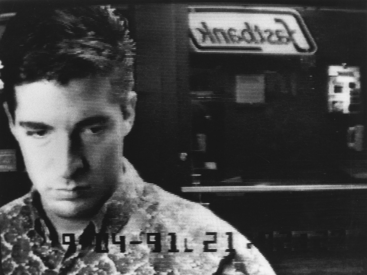 Black and white photograph of a man at an ATM